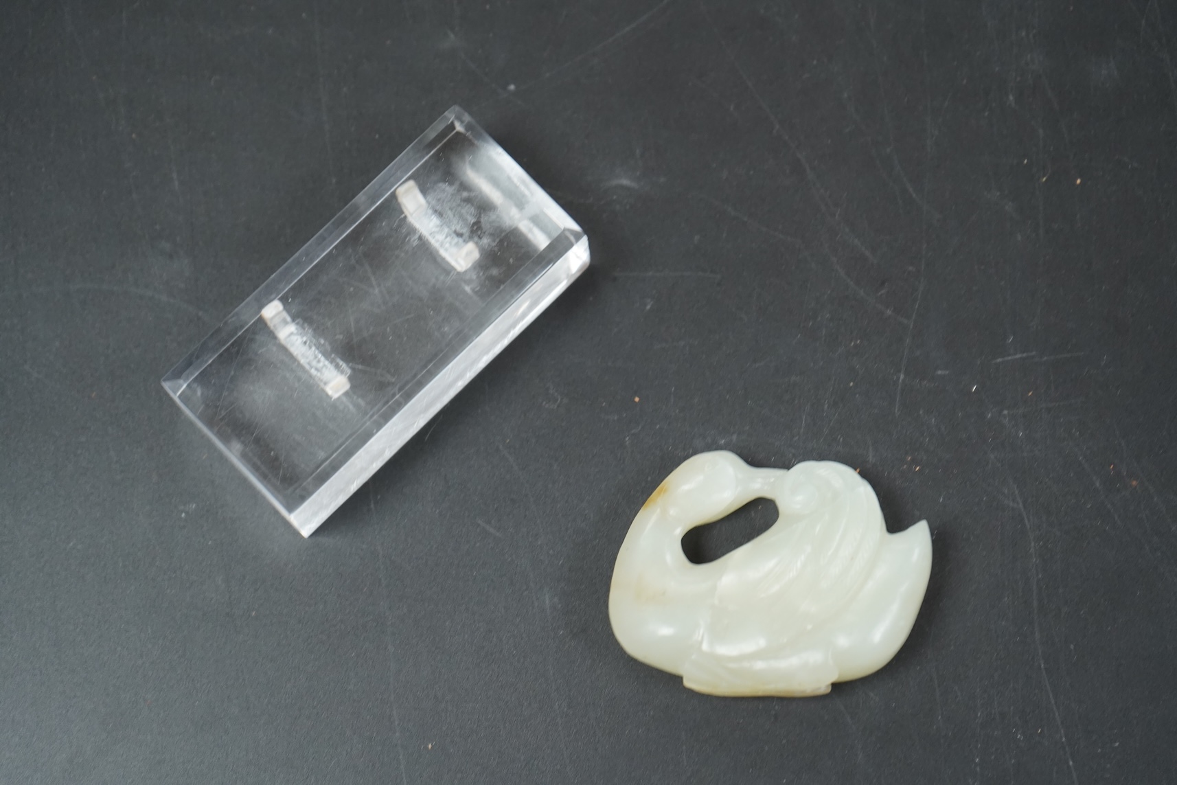 A Chinese celadon jade carving of a duck, Qing, with perspex stand, 5cm wide